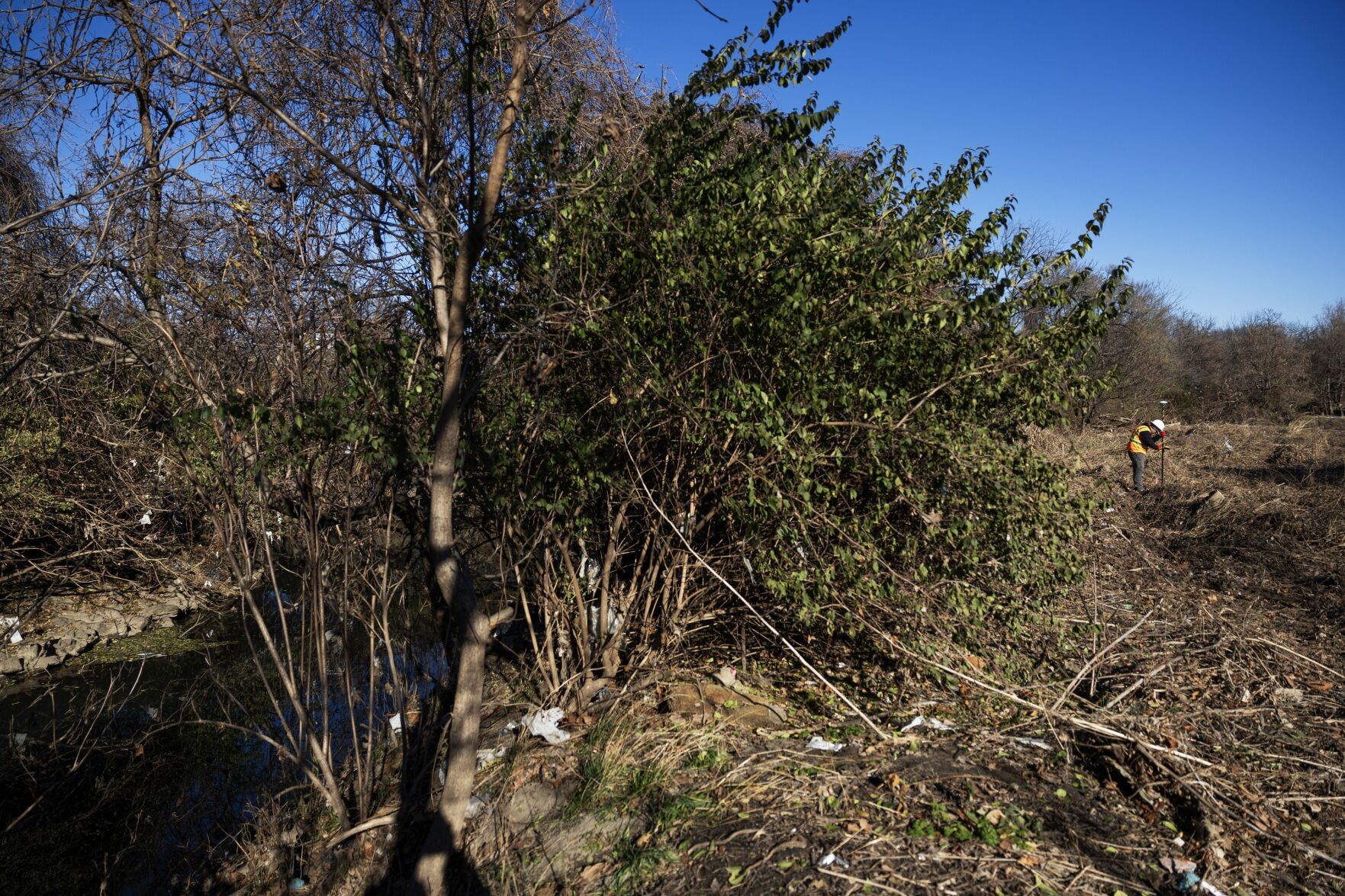 Contractors with the Army Corps of Engineers install signage along Coldwater Creek